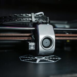 Detailed close-up view of a modern 3D printer in operation, focusing on the printhead.